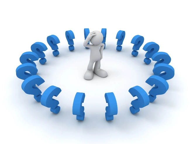 Man Looking Confused, Standing In The Middle Of A Circle Of Question Marks